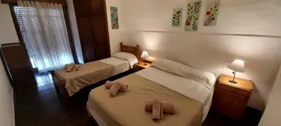 two beds in a hotel room with towels on them at Departamento Alta Gracia in Alta Gracia