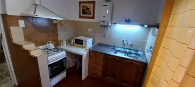 a small kitchen with a sink and a microwave at Departamento Alta Gracia in Alta Gracia