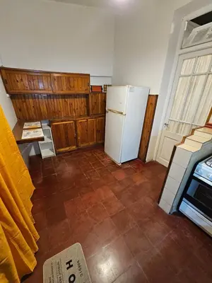 a kitchen with a refrigerator and a tile floor at Departamento Alta Gracia in Alta Gracia