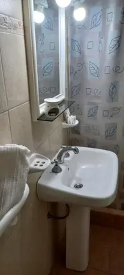 a bathroom with a white sink and a mirror at Departamento Alta Gracia in Alta Gracia