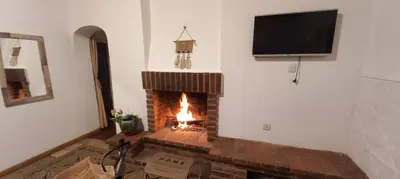 a living room with a brick fireplace with a flat screen tv at Departamento Alta Gracia in Alta Gracia