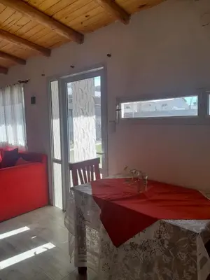 a dining room with a red table and a window at Cabañas cochico in Villa Carlos Paz