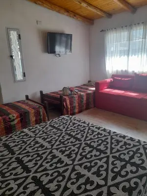 a living room with a couch and a tv at Cabañas cochico in Villa Carlos Paz