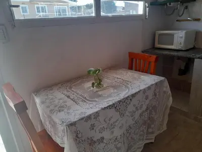a table in a kitchen with a white table cloth at Cabañas cochico in Villa Carlos Paz