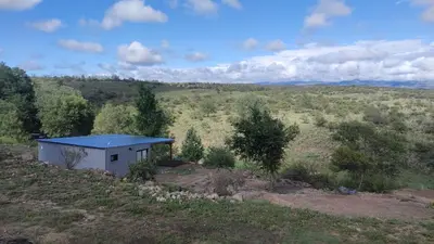 a small building with a blue roof in a field at Los Ceibos Suites in Villa Ciudad de America
