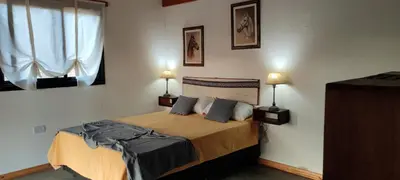 a bedroom with a bed with two lamps on the wall at Los Ceibos Suites in Villa Ciudad de America