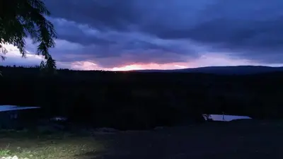 a sunset over the mountains with a bench in the foreground at Los Ceibos Suites in Villa Ciudad de America