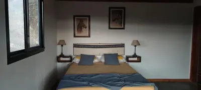 a bedroom with a bed with blue pillows and two lamps at Los Ceibos Suites in Villa Ciudad de America