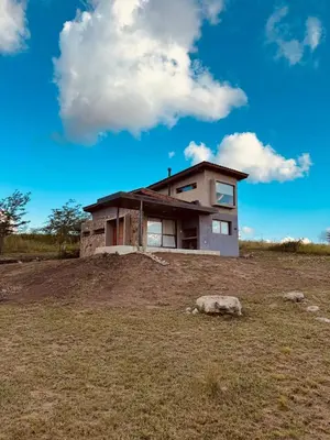a house on top of a hill in a field at Cuatro Soles in Villa Yacanto