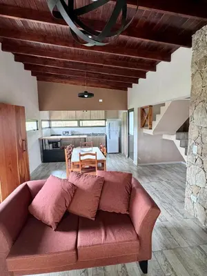 a living room with a red couch and a table at Cuatro Soles in Villa Yacanto