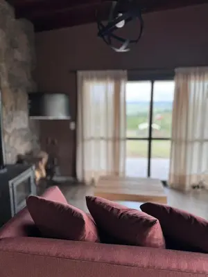 a red couch with pillows in a living room at Cuatro Soles in Villa Yacanto