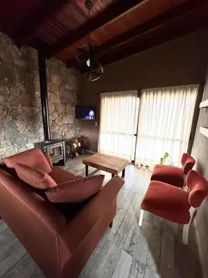 a living room with a couch and chairs and a fireplace at Cuatro Soles in Villa Yacanto