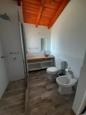 a bathroom with two toilets and a sink at Cabañas Altos de Kamiâre in Villa Yacanto