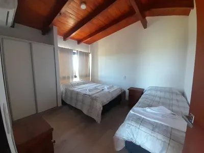 a bedroom with two beds and a wooden ceiling at Cabañas Altos de Kamiâre in Villa Yacanto