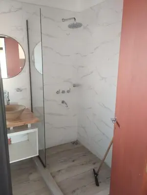 a bathroom with a glass shower and a sink at Cabañas Altos de Kamiâre in Villa Yacanto