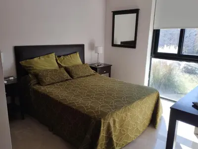 a bedroom with a bed and a large window at Paraíso Serrano 17 in Villa Ciudad Parque