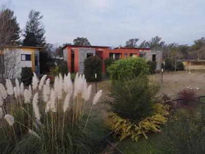 a garden with white plants and buildings in the background at Paraíso Serrano 17 in Villa Ciudad Parque