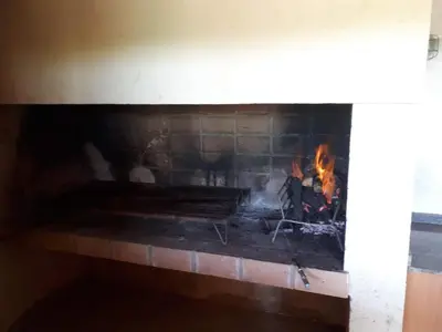 a brick fireplace with a fire in it at Paraíso Serrano 17 in Villa Ciudad Parque