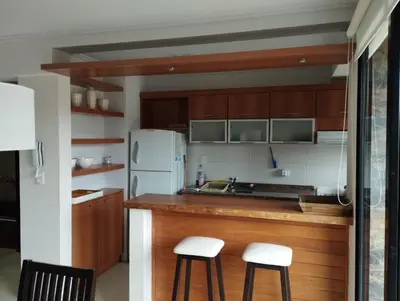 a kitchen with wooden cabinets and white appliances at Paraíso Serrano 17 in Villa Ciudad Parque