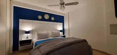 a bedroom with a bed with a blue head board at Magestic Barrio General Paz in Cordoba