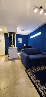 a living room with a couch and a blue wall at Magestic Barrio General Paz in Cordoba