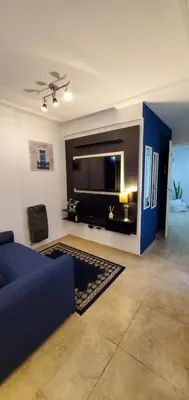 a living room with a blue couch and a large tv at Magestic Barrio General Paz in Cordoba