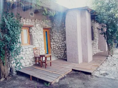 a wooden porch of a house with a chair on it at Las cuatro estaciones in Merlo