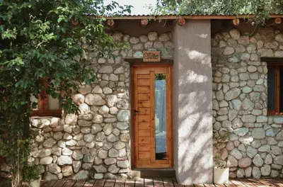 a stone building with a door and a sign on it at Las cuatro estaciones in Merlo