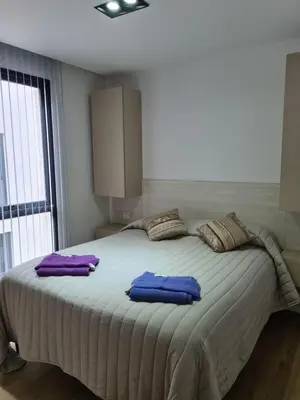 a bedroom with a large bed with purple pillows on it at Apart Suite Premiun in Villa Carlos Paz