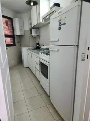 a kitchen with a white refrigerator and white cabinets at Departamento -Obispo Salguero- Pleno Nueva Córdoba, cerca de Sanatorios, By Apartcba in Cordoba