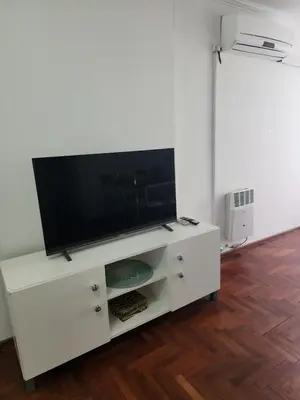 a white entertainment center with a flat screen tv on it at Departamento -Obispo Salguero- Pleno Nueva Córdoba, cerca de Sanatorios, By Apartcba in Cordoba