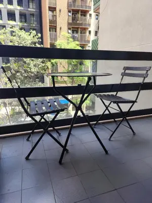 a glass table and two chairs in front of a window at Departamento -Obispo Salguero- Pleno Nueva Córdoba, cerca de Sanatorios, By Apartcba in Cordoba
