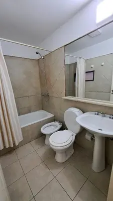 a bathroom with a toilet and a sink and a mirror at Departamento -Obispo Salguero- Pleno Nueva Córdoba, cerca de Sanatorios, By Apartcba in Cordoba