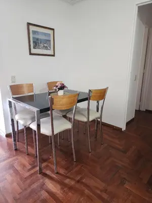 a dining room table and chairs with flowers on it at Departamento -Obispo Salguero- Pleno Nueva Córdoba, cerca de Sanatorios, By Apartcba in Cordoba