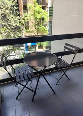 a table and two chairs on a balcony with a window at Departamento -Obispo Salguero- Pleno Nueva Córdoba, cerca de Sanatorios, By Apartcba in Cordoba