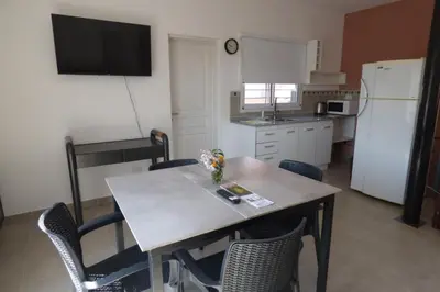 a kitchen with a table and chairs and a white refrigerator at Apart Loma Linda in Merlo