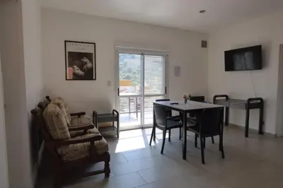 a living room with a table and chairs and a window at Apart Loma Linda in Merlo
