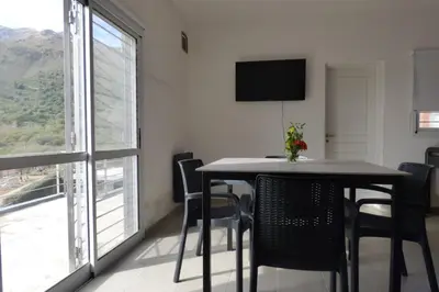 a dining room with a table and chairs and a window at Apart Loma Linda in Merlo
