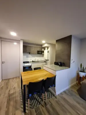 a kitchen with a wooden table and chairs at Departamento Scala in Cordoba