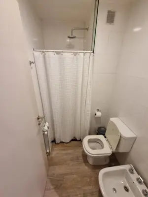 a white bathroom with a toilet and a sink at Departamento Scala in Cordoba