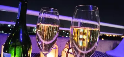 two glasses of champagne sitting on a table with a bottle at Fabuloso apartamento con terraza y asador propios in Cordoba