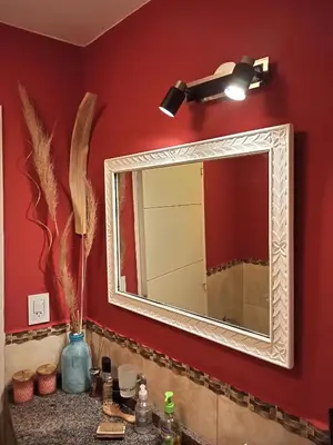 a bathroom sink with a mirror on a red wall at Fabuloso apartamento con terraza y asador propios in Cordoba