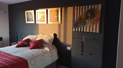 a bedroom with a bed with red pillows on it at Fabuloso apartamento con terraza y asador propios in Cordoba