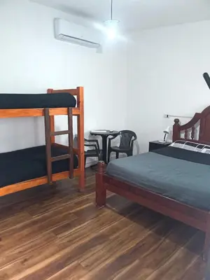 a room with three bunk beds and a table at El kincho hostel bike in La Cruz