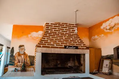 a living room with a brick fireplace with a painting at El kincho hostel bike in La Cruz