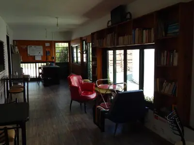 a living room with red chairs and a table at El kincho hostel bike in La Cruz