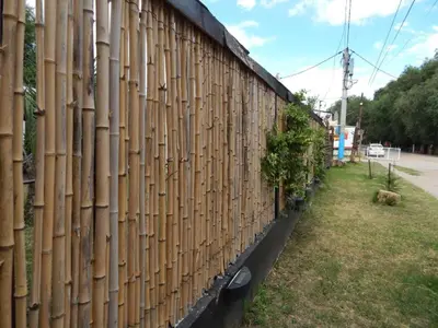 a fence with bamboo panels on the side of a building at El kincho hostel bike in La Cruz