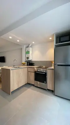 a kitchen with a stainless steel refrigerator and a sink at Duplex en el Cerro de Las Rosas by Lugar in Cordoba