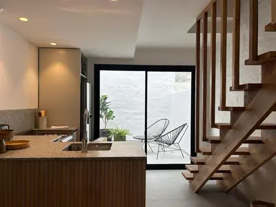 a kitchen with a staircase and a table and a chair at Duplex en el Cerro de Las Rosas by Lugar in Cordoba