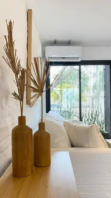 two vases sitting on a table next to a bed at Duplex en el Cerro de Las Rosas by Lugar in Cordoba